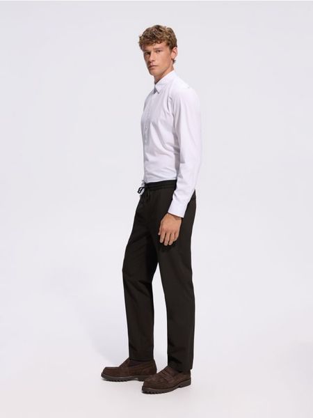 Spodnie jogger - brązowy. Brązowe joggery i bojówki Reserved, l, bez wzorów, z tkaniny. Za 149.99 zł.