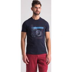 Granatowy t-shirt męski z nadrukiem - Granatowy. Niebieskie t-shirty Emporio Armani, l, bez wzorów, z bawełny, bez kołnierzyka, bez ramiączek. Za 219.60 zł.
