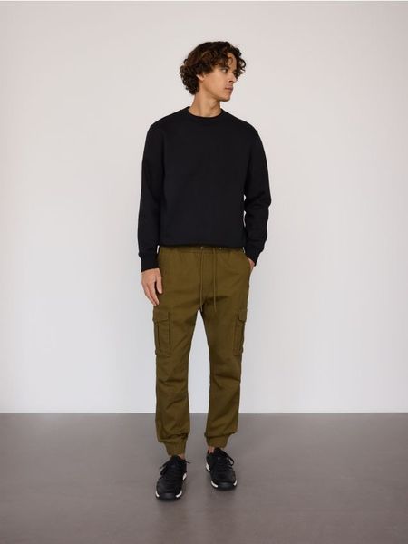 Spodnie cargo jogger - zielony. Zielone joggery i bojówki Reserved, l, bez wzorów, z bawełny. W wyprzedaży za 99.99 zł.