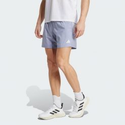 Szorty Own The Run. Szare szorty Adidas, bez wzorów, z materiału, sportowe. W wyprzedaży za 149.65 zł.