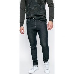 Wrangler - Jeansy Strangler Rinse. Niebieskie jeansy Wrangler, z podwyższonym stanem. W wyprzedaży za 129.90 zł.
