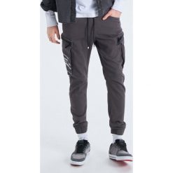 Elastyczne spodnie slim jogger - Szary. Joggery i bojówki marki Cropp. W wyprzedaży za 79.99 zł.