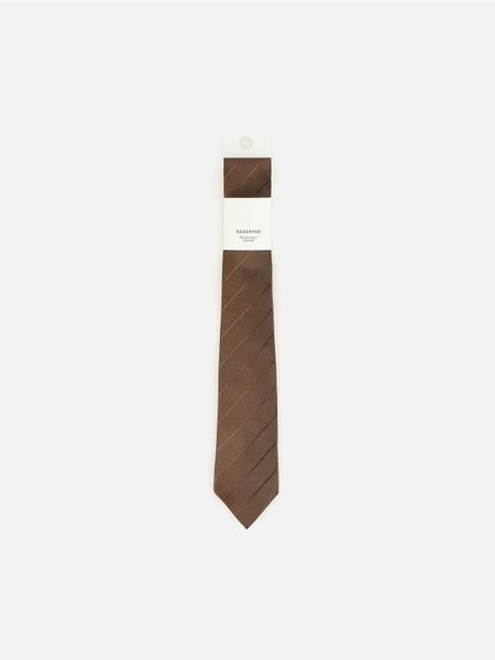 Wąski krawat - ciemnobrązowy. Brązowe krawaty i muchy Reserved, bez wzorów. Za 59.99 zł.