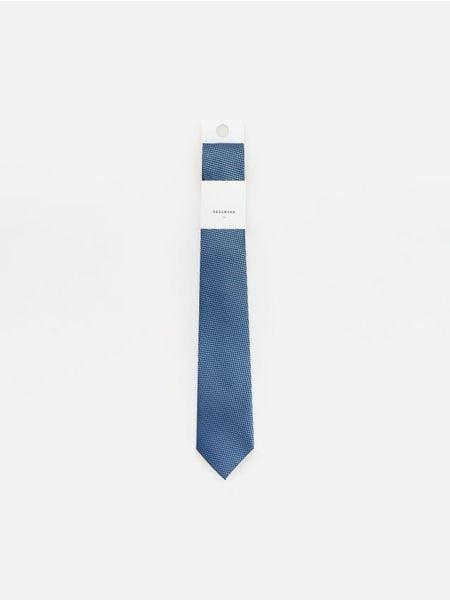Wzorzysty krawat - granatowy. Niebieskie krawaty i muchy Reserved, bez wzorów. Za 59.99 zł.