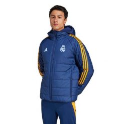 Kurtka puchowa Real Madrid Tiro 2024/25 Club. Brązowe kurtki Adidas, bez wzorów, z puchu, bez kaptura. W wyprzedaży za 477.25 zł.