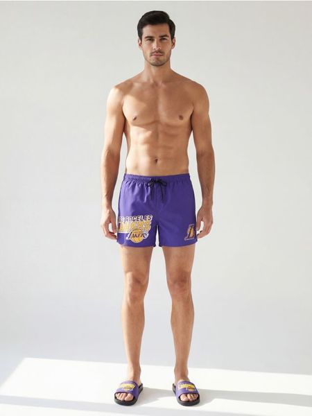 Szorty kąpielowe z nadrukiem NBA Los Angeles Lakers - fioletowy. Fioletowe krótkie spodenki sportowe Sinsay, l, bez wzorów. Za 39.99 zł.