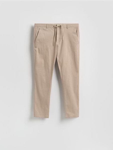 Spodnie joggery - beżowy. Brązowe joggery i bojówki Reserved, l, bez wzorów, z bawełny. Za 149.99 zł.