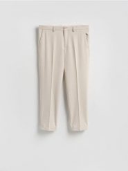 Garniturowe spodnie w kant - beżowy. Brązowe garnitury Reserved, bez wzorów, z tkaniny. Za 169.99 zł.