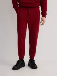 Dresowe spodnie jogger - mahoniowy. Brązowe joggery i bojówki Reserved, l, bez wzorów, z bawełny. W wyprzedaży za 59.99 zł.