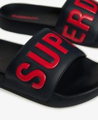 Superdry Pool Sliders – klapki męskie z wyściełanym paskiem i profilowaną. Niebieskie klapki Superdry, z poliesteru. Za 129.50 zł.