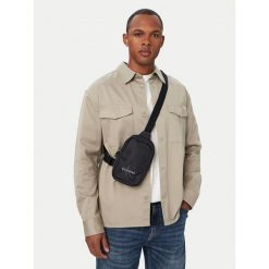 Saszetka piersiowa Calvin Klein. Czarne torby na ramię CALVIN KLEIN, bez wzorów, małe, bez dodatków. Za 249.99 zł.