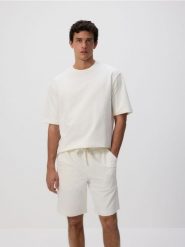 Dresowe szorty regular fit - złamana biel. Krótkie spodenki sportowe Reserved, l, bez wzorów, z bawełny. Za 79.99 zł.