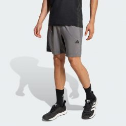SZORTY WORKOUT ESSENTIALS BASE WOVEN. Szare krótkie spodenki sportowe Adidas, l, bez wzorów, z materiału. Za 147.35 zł.