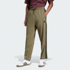 Spodnie Essentials 3-Stripes Stanford Open Hem. Brązowe spodnie treningowe długie Adidas, bez wzorów, z materiału. W wyprzedaży za 134.25 zł.