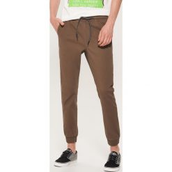 Materiałowe joggery - Brązowy. Joggery i bojówki marki House. Za 99.99 zł.