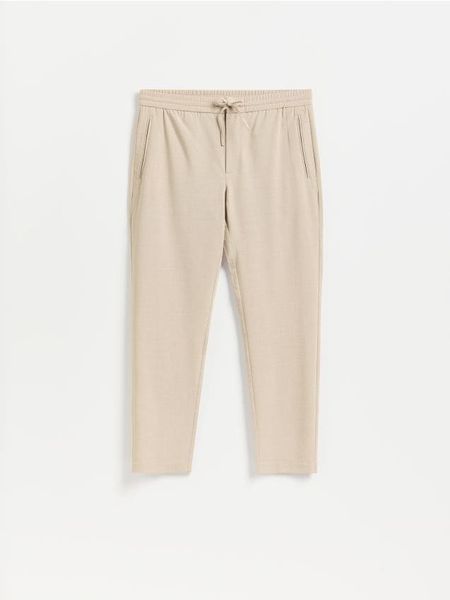 Spodnie jogger - beżowy. Brązowe joggery i bojówki Reserved, l, bez wzorów, z tkaniny. Za 149.99 zł.