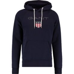 GANT SHIELD HOODIE Bluza z kapturem evening blue. Bluzy marki GANT. W wyprzedaży za 347.65 zł.
