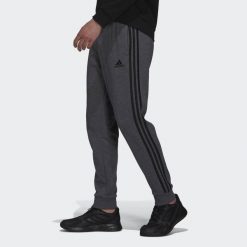 Spodnie męskie adidas Essentials French Terry Tapered Cuff 3-Stripes Pants. Czarne spodnie materiałowe Adidas, m, bez wzorów, z polaru. Za 179.99 zł.