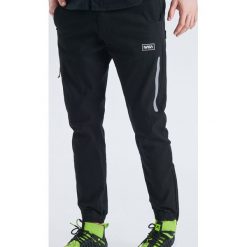 Spodnie joggery z kolekcji Nasa - Czarny. Joggery i bojówki marki Cropp. Za 129.99 zł.