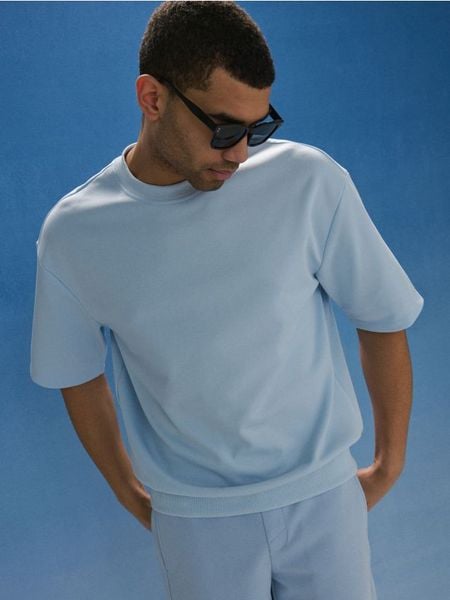 Bawełniana bluza z krótkim rękawem - błękitny. Niebieskie bluzy bez kaptura Sinsay, l, bez wzorów, z bawełny, bez kaptura. W wyprzedaży za 39.99 zł.