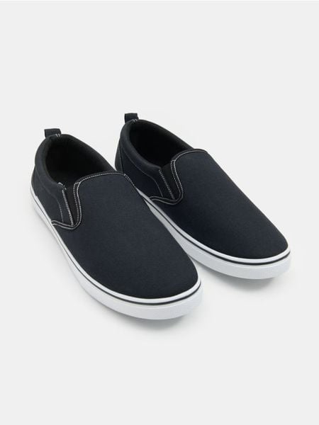 Trampki typu slip-on - czarny. Czarne trampki Sinsay, bez wzorów, bez zapięcia. Za 29.99 zł.