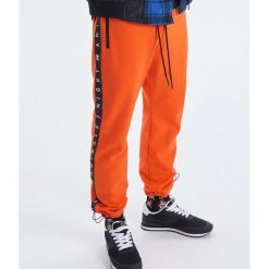 Spodnie joggery kolekcja Night Animals - Pomarańczowy. Joggery i bojówki marki Cropp. Za 119.99 zł.