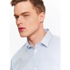 KOSZULA MĘSKA O DOPASOWANYM KROJU Z NADRUKOWANYM WZOREM I KOŁNIERZYKIEM TYPU KENT. Koszule marki TOP SECRET. W wyprzedaży za 39.99 zł.