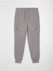 Spodnie jogger z kieszeniami na zamek i przeszyciami - szary. Szare joggery i bojówki Sinsay, l, bez wzorów, sportowe. Za 79.99 zł.