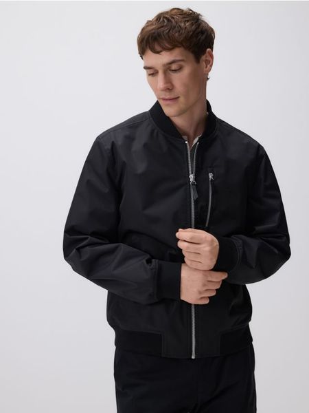 Gładka bomberka - czarny. Czarne kurtki Reserved, l, bez wzorów, z tkaniny, bez kaptura. W wyprzedaży za 139.99 zł.