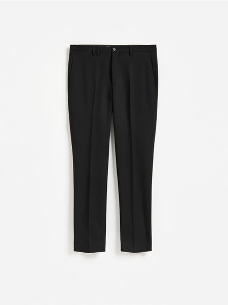 Garniturowe spodnie slim fit - czarny. Czarne garnitury Reserved, l, bez wzorów, z tkaniny. Za 169.99 zł.