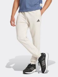 Adidas Spodnie dresowe w kolorze kremowym rozmiar: XL. Brązowe spodnie treningowe długie Adidas, xl, bez wzorów, z dresówki. Za 190.18 zł.