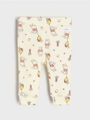 Bawełniane legginsy ze wzorem Winnie the Pooh - beżowy. Brązowe legginsy długie sportowe Sinsay, l, bez wzorów, z bawełny. Za 12.99 zł.
