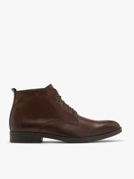 Brązowe trzewiki z przeszyciami na cholewce. Brązowe botki sznurowane Ryłko, bez wzorów, ze skóry, bez obcasa, bez zapięcia. Za 499.99 zł.