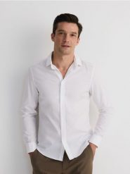 Bawełniana koszula slim fit - biały. Białe koszule Reserved, l, bez wzorów, z bawełny, bez kołnierzyka, bez ramiączek. Za 119.99 zł.