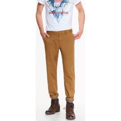 SPODNIE MĘSKIE CHINO Z OPRANEJ BAWEŁNY O REGULARNYM KROJU. Brązowe eleganckie spodnie TOP SECRET, na co dzień, na jesień, m, z bawełny. W wyprzedaży za 39.99 zł.