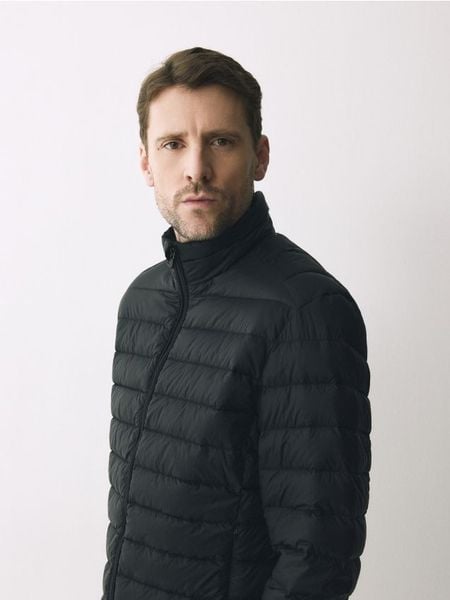 Puchowa kurtka z pokrowcem - czarny. Czarne kurtki Reserved, l, bez wzorów, z puchu, bez kaptura. Za 299.99 zł.