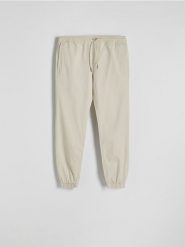 Spodnie jogger slim - złamana biel. Joggery i bojówki Reserved, l, bez wzorów, z bawełny. W wyprzedaży za 99.99 zł.
