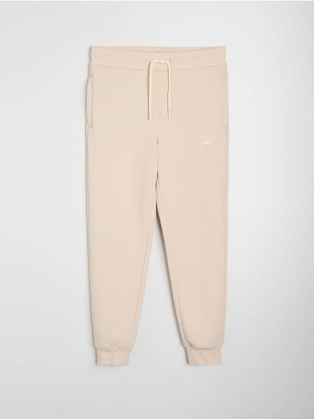 Spodnie jogger slim fit - beżowy. Brązowe joggery i bojówki Sinsay, l, bez wzorów, sportowe. Za 49.99 zł.