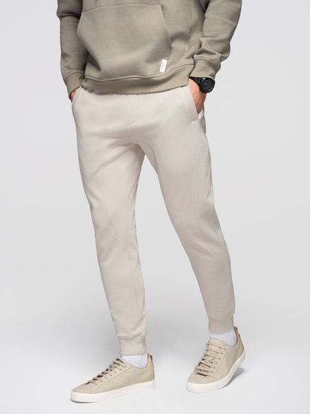 Spodnie męskie dresowe ze ściągaczem przy nogawce BASIC jogger - jasnobeżowe V1 - Rozmiar: S. Szare joggery i bojówki Ombre Clothing, m, z aplikacjami, z bawełny. W wyprzedaży za 118.99 zł.