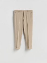 Garniturowe spodnie carrot - beżowy. Brązowe garnitury Reserved, bez wzorów, z tkaniny. Za 169.99 zł.