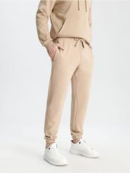 Spodnie dresowe jogger - beżowy. Brązowe joggery i bojówki Sinsay, l, bez wzorów, z bawełny, sportowe. Za 29.99 zł.