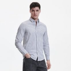 Bawełniana koszula regular fit - granatowy. Niebieskie koszule Reserved, l, bez wzorów, z bawełny, bez kołnierzyka, bez ramiączek. W wyprzedaży za 89.99 zł.