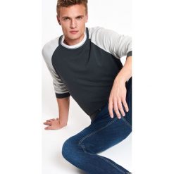 SWETER MĘSKI Z OKRĄGŁYM DEKOLTEM I KONTRASTOWYMI RĘKAWAMI. Golfy marki TOP SECRET. W wyprzedaży za 49.99 zł.
