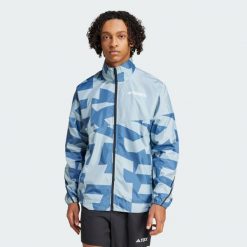 Wiatrówka Terrex Multi Printed. Niebieskie kurtki do biegania Adidas, s, bez wzorów, z materiału, bez kaptura, do biegania. W wyprzedaży za 316.55 zł.