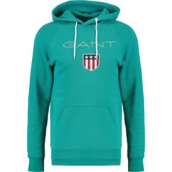 GANT SHIELD HOODIE Bluza z kapturem emerald green. Bluzy marki GANT. W wyprzedaży za 356.15 zł.