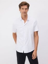 Koszula regular fit z bawełną - biały. Białe koszule Reserved, l, bez wzorów, z bawełny, bez kołnierzyka, bez ramiączek. Za 99.99 zł.