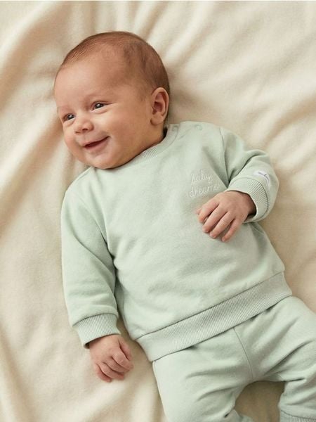 Bawełniana bluza z napisem na plecach - zielony. Zielone bluzy bez kaptura Sinsay, l, bez wzorów, z bawełny, bez kaptura. Za 11.99 zł.