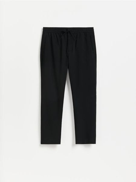 Spodnie jogger - czarny. Czarne joggery i bojówki Reserved, l, bez wzorów, z tkaniny. Za 149.99 zł.
