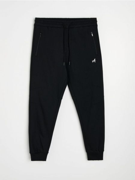 Spodnie dresowe regular jogger - czarny. Czarne joggery i bojówki Sinsay, l, bez wzorów, z dresówki. Za 59.99 zł.