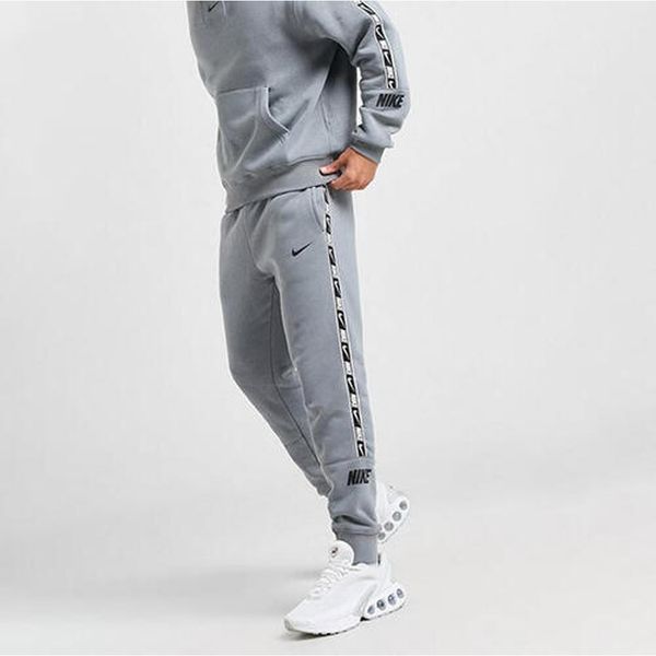 Spodnie Dresowe Męskie Nike Nsw Repeat Tape Jogger. Szare joggery i bojówki Nike, m, bez wzorów, z dresówki, sportowe. Za 215.60 zł.